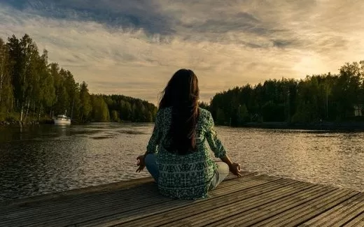 Chica meditando frente a la naturaleza